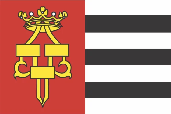 Drachtster vlag met rood vlak, geel historisch symbool en zeven afwisselende witte en zwarte banen