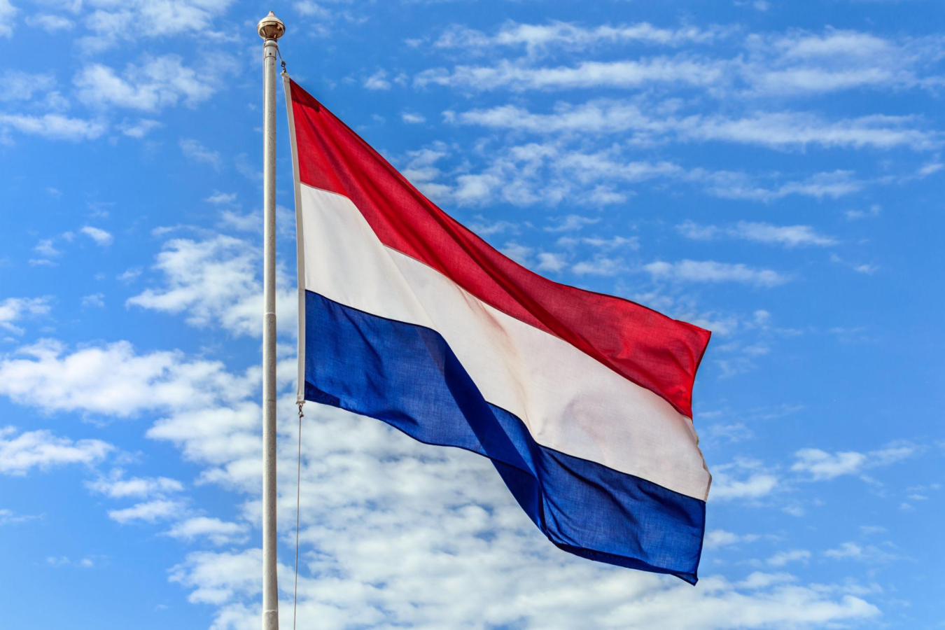 Hollandse vlag in rood wit blauw aan een vlaggenmast